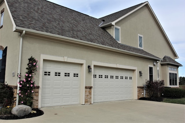 6884 Ballantrae Pl, Dublin, OH 43016 - view of side of home with concrete driveway, stone siding, and stucco siding