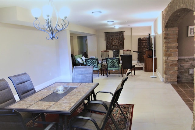 6884 Ballantrae Pl, Dublin, OH 43016 - tiled dining room with baseboards, arched walkways, and a chandelier