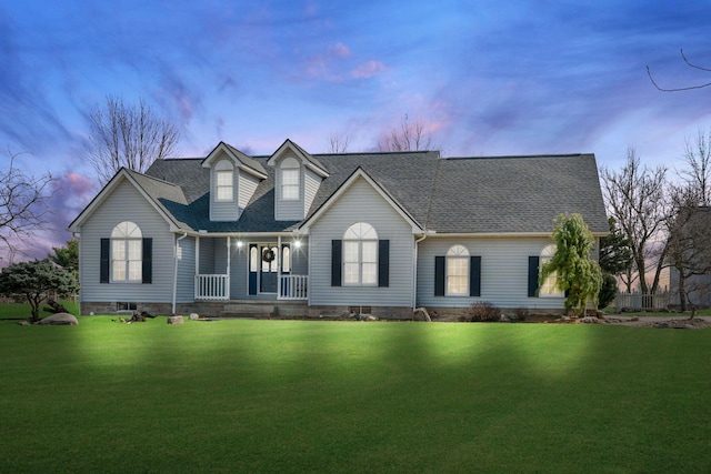 new england style home with a front lawn, covered porch, and a shingled roof