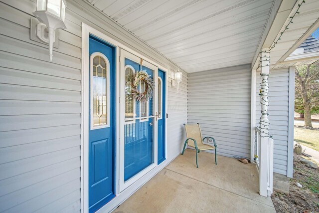 view of exterior entry featuring covered porch