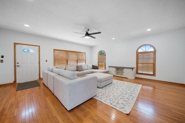 living room featuring recessed lighting, light wood-type flooring, a textured ceiling, and ceiling fan