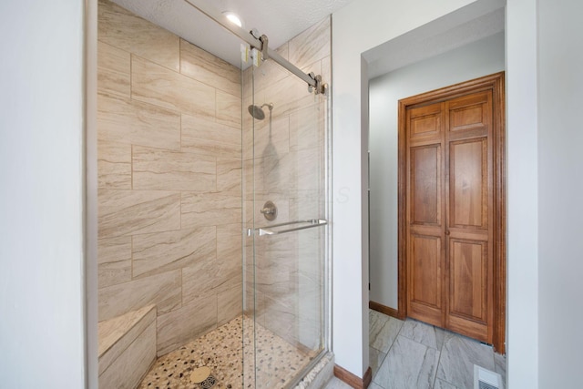 full bath with a shower stall, baseboards, visible vents, and marble finish floor