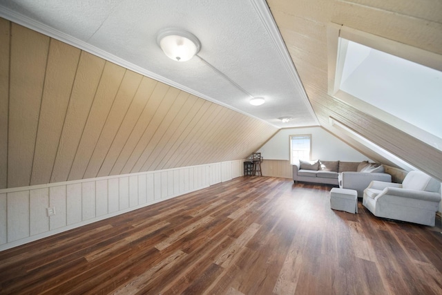 bonus room with lofted ceiling, wood finished floors, and a textured ceiling