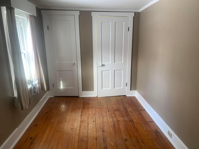 unfurnished bedroom featuring baseboards and wood-type flooring