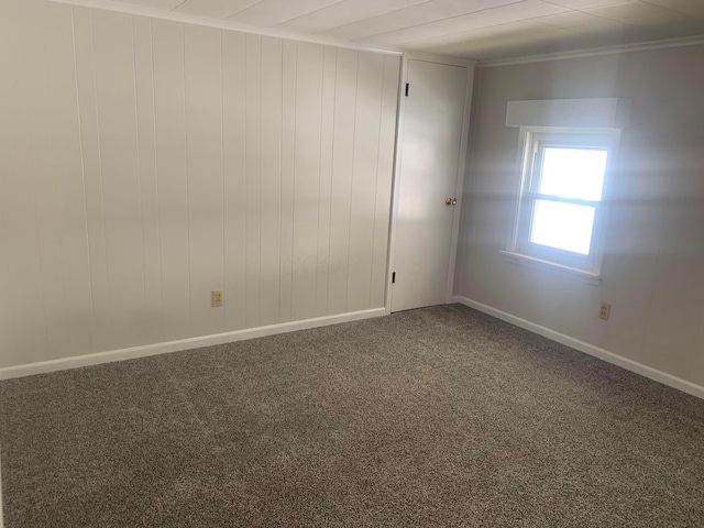 carpeted empty room featuring baseboards and ornamental molding