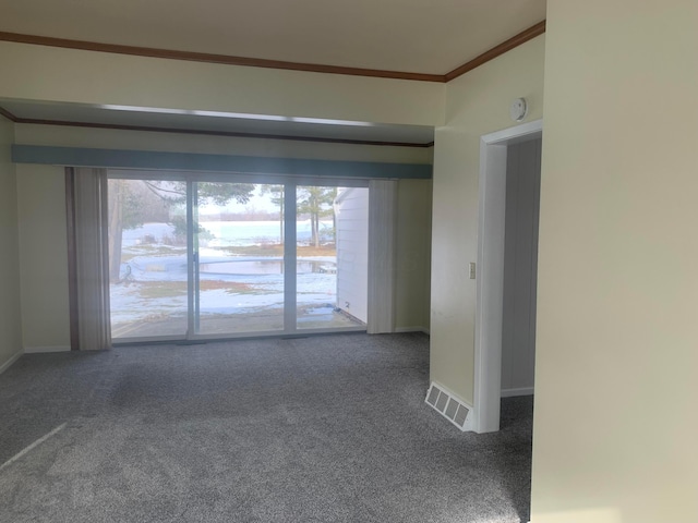 carpeted spare room featuring visible vents, baseboards, and ornamental molding