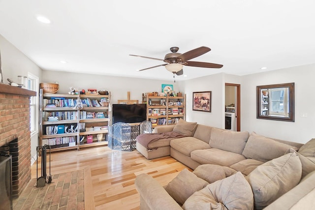 living area featuring recessed lighting, wood finished floors, a brick fireplace, and ceiling fan