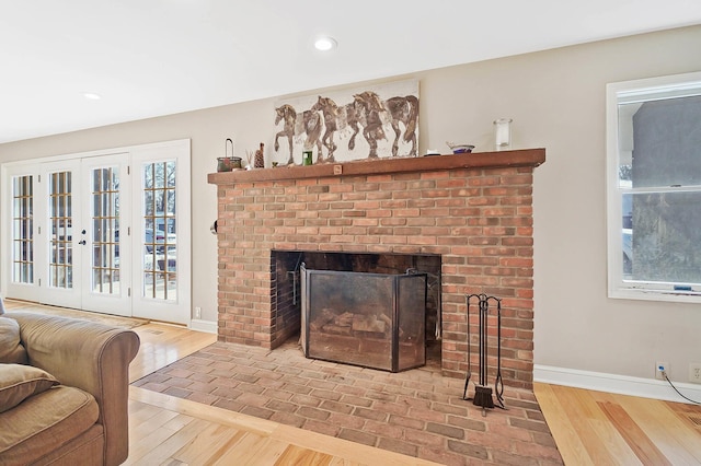 living area featuring recessed lighting, baseboards, a brick fireplace, and wood finished floors