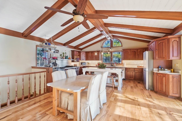 dining room featuring light wood-style flooring, vaulted ceiling with beams, and ceiling fan