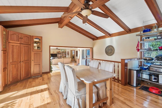 dining area featuring lofted ceiling with beams, light wood-style floors, and ceiling fan