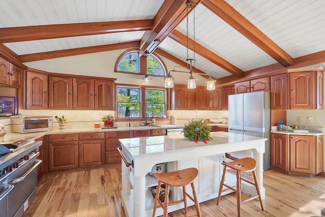 kitchen with a breakfast bar area, a sink, stainless steel appliances, light wood-style floors, and tasteful backsplash