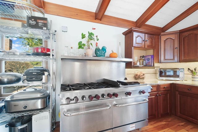 kitchen with vaulted ceiling with beams, appliances with stainless steel finishes, wooden ceiling, light wood-type flooring, and backsplash