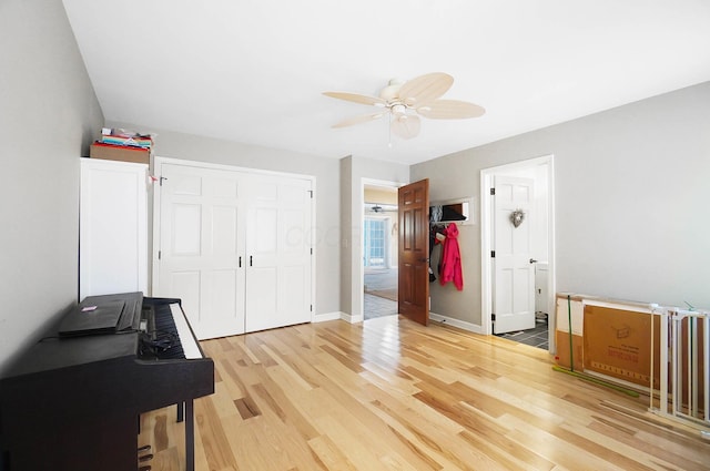 interior space with baseboards, light wood-type flooring, and a ceiling fan