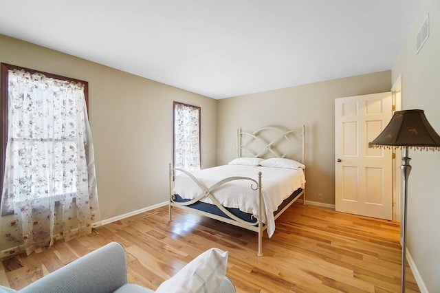 bedroom featuring light wood-style flooring, baseboards, and visible vents