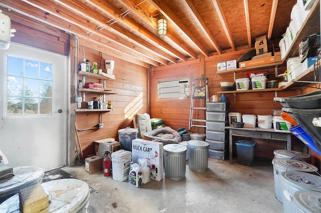 miscellaneous room with wooden walls and unfinished concrete floors