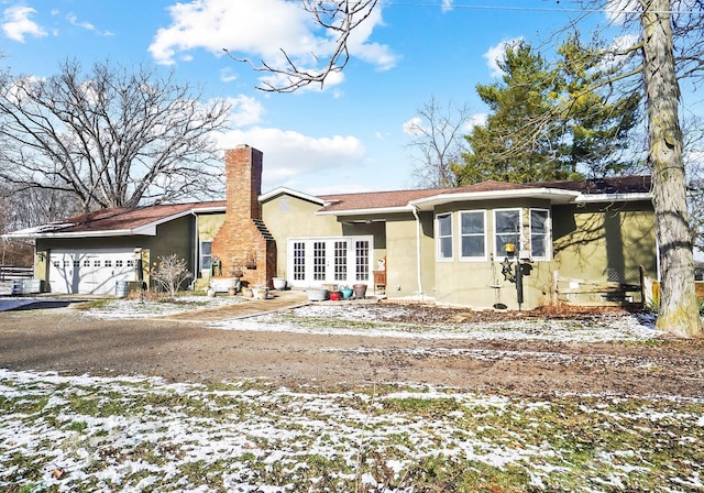 ranch-style home featuring stucco siding and a chimney