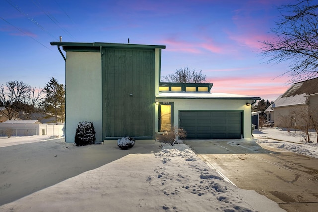 view of front of home featuring a garage, driveway, and stucco siding