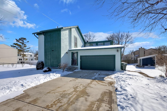 exterior space featuring stucco siding, concrete driveway, and fence