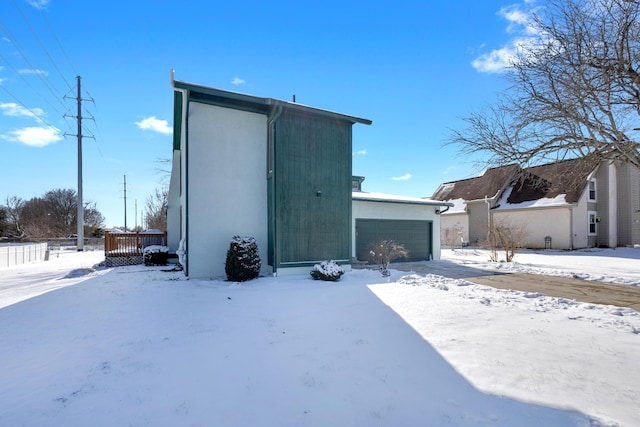 snow covered structure featuring a garage