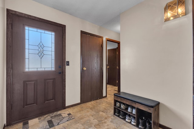 entryway with a textured ceiling and baseboards