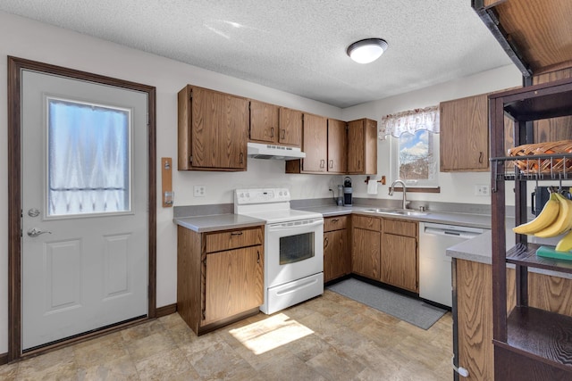 kitchen featuring white range with electric cooktop, under cabinet range hood, dishwasher, brown cabinets, and a sink