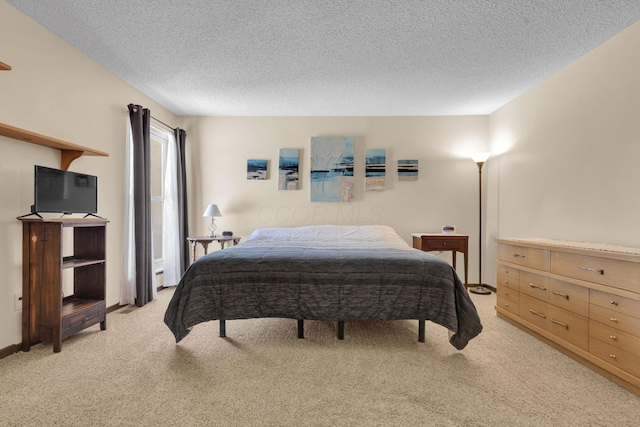 bedroom with light colored carpet and a textured ceiling