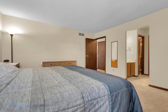 bedroom with visible vents, light carpet, a textured ceiling, and baseboards