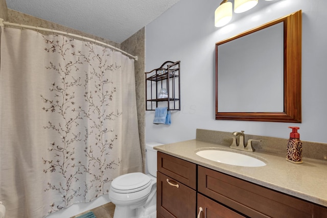 bathroom with vanity, toilet, and a textured ceiling