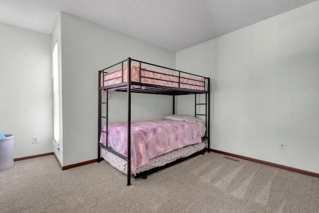 unfurnished bedroom featuring carpet flooring, visible vents, baseboards, and a textured ceiling