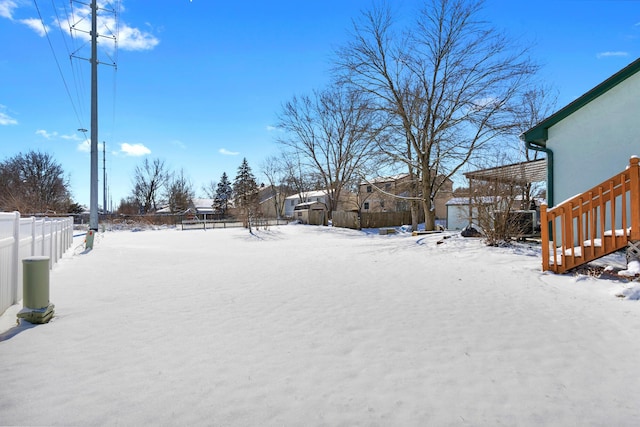 yard covered in snow featuring fence