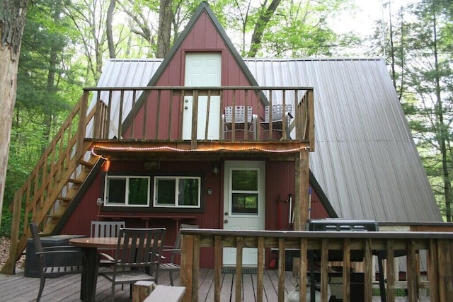 back of house featuring metal roof, stairs, and a deck