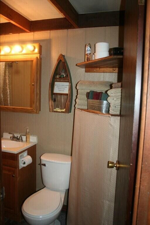 bathroom with vanity, beam ceiling, and toilet