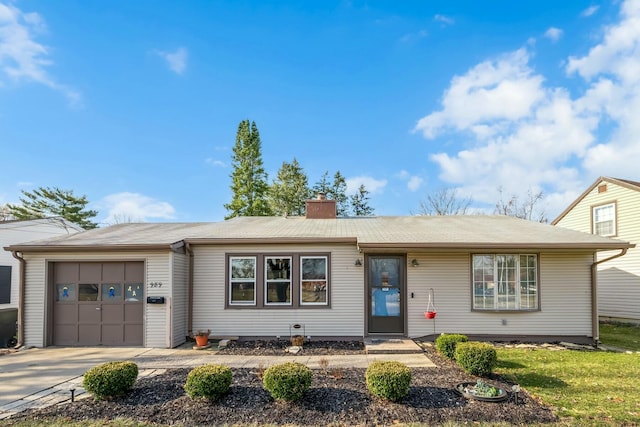 single story home featuring concrete driveway, an attached garage, and a chimney