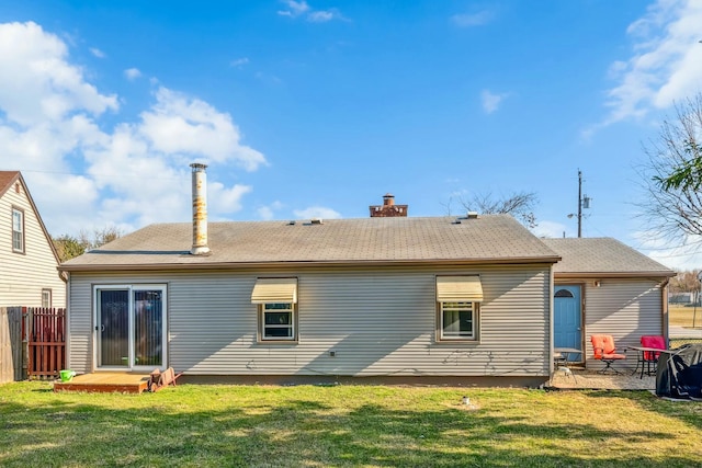 rear view of property with a yard, fence, and a chimney