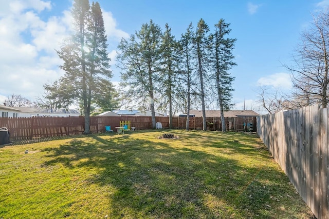 view of yard featuring a fire pit and a fenced backyard