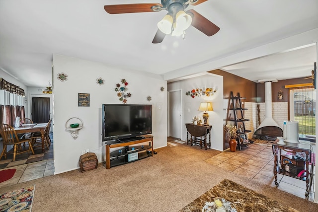 living area featuring a wood stove, carpet, and a ceiling fan