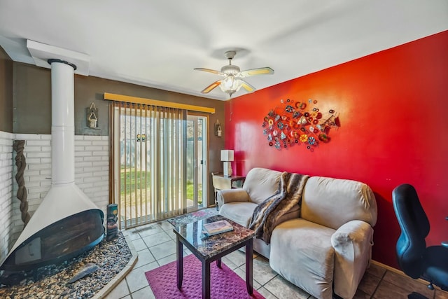 tiled living room with ceiling fan and a wood stove