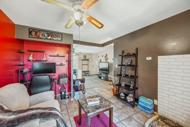 living room with an accent wall, tile patterned floors, and ceiling fan