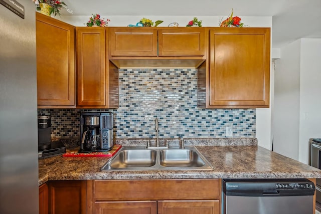 kitchen with tasteful backsplash, stainless steel dishwasher, dark countertops, and a sink