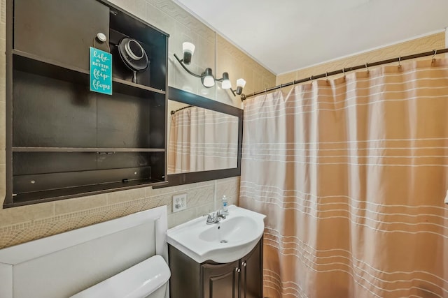 full bathroom with vanity, tile walls, and toilet