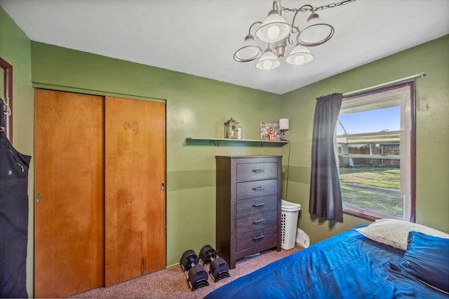 carpeted bedroom with a closet and a notable chandelier