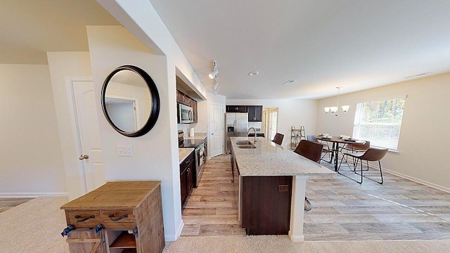 45 Genoa Cir, Commercial Point, OH 43116 - kitchen with stainless steel appliances, a sink, baseboards, a chandelier, and a kitchen breakfast bar