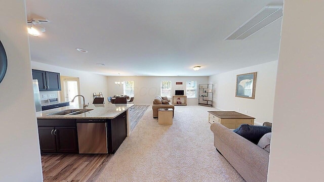 45 Genoa Cir, Commercial Point, OH 43116 - kitchen with appliances with stainless steel finishes, a sink, open floor plan, a chandelier, and light stone counters