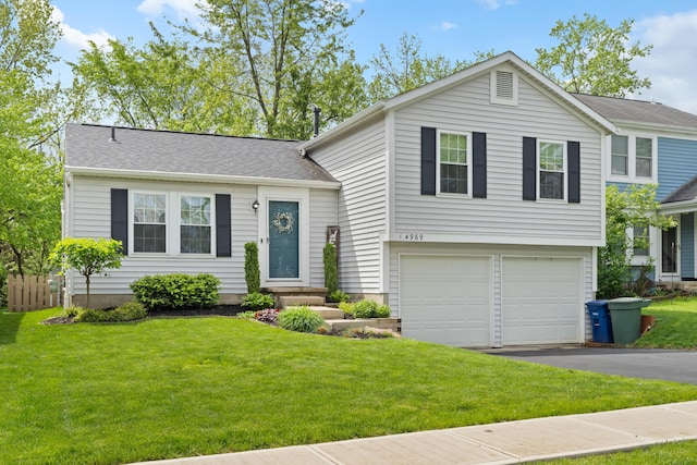 tri-level home featuring driveway, a garage, and a front lawn