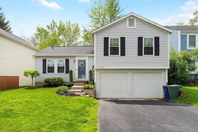 tri-level home featuring a garage, asphalt driveway, and a front yard