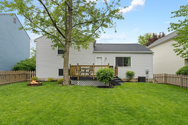 rear view of house featuring a deck, a fire pit, and roof with shingles