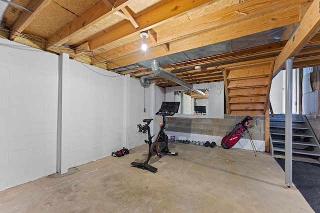 unfinished below grade area with stairway and concrete block wall