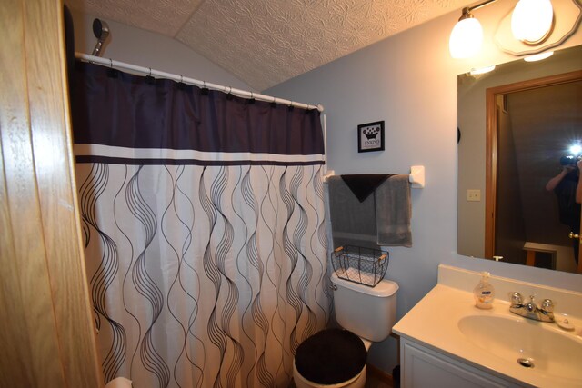 bathroom featuring toilet, curtained shower, a textured ceiling, lofted ceiling, and vanity