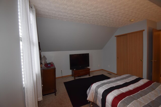 carpeted bedroom featuring baseboards, a textured ceiling, and lofted ceiling