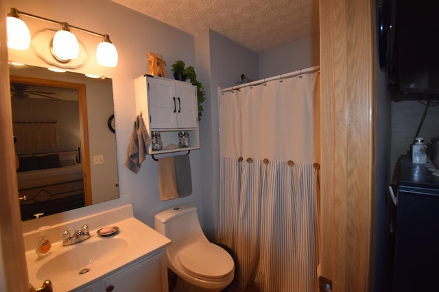bathroom featuring vanity, curtained shower, toilet, and a textured ceiling